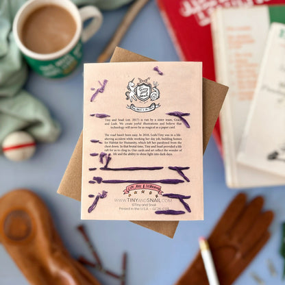 Card with text and illustrations on a table with a mug and books