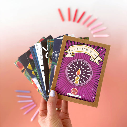 Hand holding a colorful card with a purple design against a gradient background